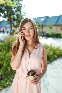 Güzel kız elbisesi, aramalar, sesli mesaj cep telefonu, uygulama interneti, sosyal ağlar, yaz şehri, modern moda tarzı. Çay ile bir fincan kahve..