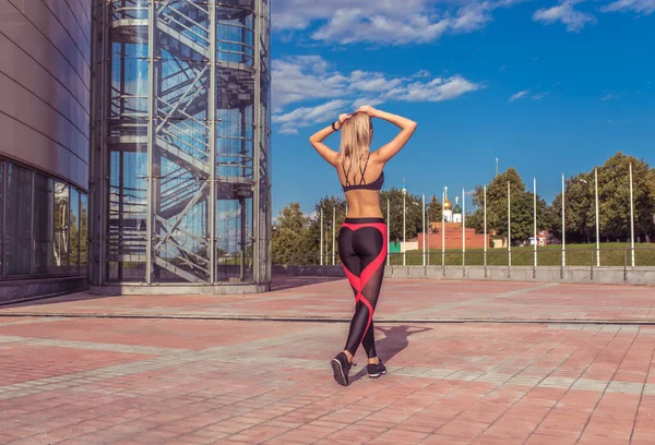 Atleta menina caminha descanso treinamento após correr, cidade do dia de verão. Gosta de andar. Aptidão de estilo de vida ativo, mulher elegante na moda. Vista de volta, texto de motivação de espaço livre. Sportswear figura bronzeada . — Fotografia de Stock