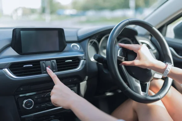 Close-up, woman in car, clicks on emergency stop button. Safety on road on city, activation of alarm signal, emergency essence, problem on road, warning drivers. Right-hand drive, left-hand drive. — Stock Photo, Image