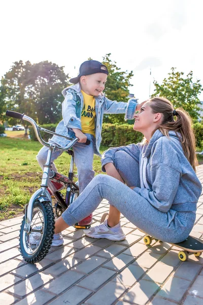 Ibu keluarga anak laki-laki anak laki-laki berusia 3-5 tahun, kota musim panas, mengajarkan bagaimana naik sepeda, bermain-main, emosi sukacita relaksasi akhir pekan, cinta. Pakaian sehari-hari, mengasuh anak . — Stok Foto