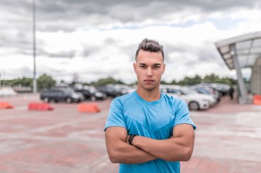 Erkek sporcu, idmandan sonra dinleniyor, kendine güvenen, güçlü ve istekli görünüyor, şehirde yaz sporu yapıyor. Gençlik yaşam tarzı spor motivasyonu. Metni kopyalamak için boş alan.