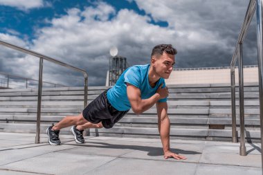 Genç sporcu, erkek sporcu, bardaki barlarda, yazın şehirde şınav, spor antrenmanı eğitimi, modern gençliğin aktif yaşam tarzı, spor kıyafeti şortu spor ayakkabıları. Yaşam motivasyonu.