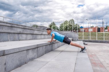 Genç sporcu, erkek atlet, bardan şınav çekiyor, yaz şehri, fitness antrenmanı, modern gençliğin aktif yaşam tarzı, spor giyim. Yaşam için motivasyon. Boş alan kopyalama metni.