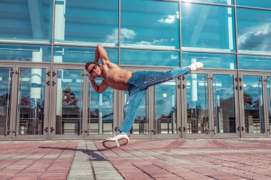 Man dancer, muscle jump in flight, dancing breakdance, summer in city, free space for text, hip-hop break dancer. Youth lifestyle, active, trend modern, fitness sport, positive motivation.