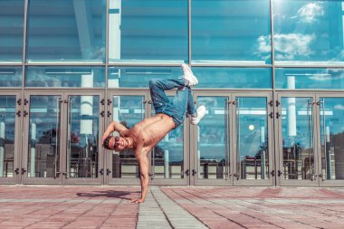 Man dancer, stand on one arm, dancing breakdance, summer in city, free space for text, hip-hop break dancer. Youth lifestyle, active, trend modern, fitness sport, positive motivation.