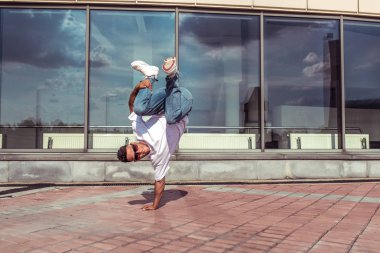 Yaz şehrinde erkek dansçı, break dans moda ve modern hip-hop dansı tarzı. Sokak hayatı. Metni kopyalamak için boş alan.