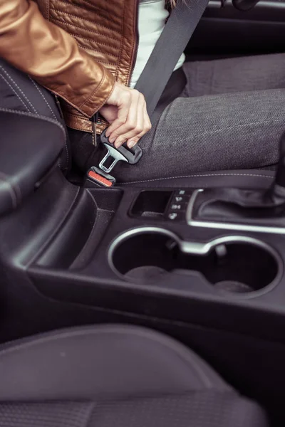 Mulher no carro, sentado ao volante de um carro, aperta seu cinto de segurança, ativa airbags, desprende seu cinto no estacionamento, close-up transmissão automática . — Fotografia de Stock