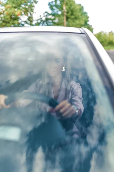 Крупный план автомобиля лобовое стекло, деловая женщина в машине, летний и осенний день в городе, вождение автомобиля во время вождения . — стоковое фото