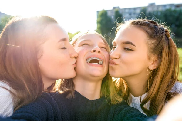 3 anak perempuan remaja sekolah 13-15 tahun, di musim gugur, di musim panas di kota, mengambil gambar selfie di smartphone, Internet sosial. Bersenang-senang, santai, tertawa dan bergembira. Brace pada gigi . — Stok Foto