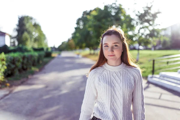 Happy smiling Girl teenager 12-15 years old, autumn day, street portrait, knitted white sweater, summer park. Resting after school. Free space for copy text, concept parenting thoughts adolescents. — ストック写真