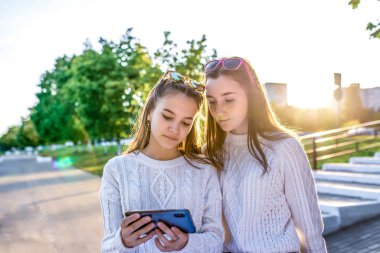 2 kız, liseli kızlar, 13-15 yaşları arasında, sonbahar günü, yaz kenti, videolu telefon, internet uygulaması. Eğlence kankaları. Okuldan sonra sokakta dinlen. Günlük kıyafet..