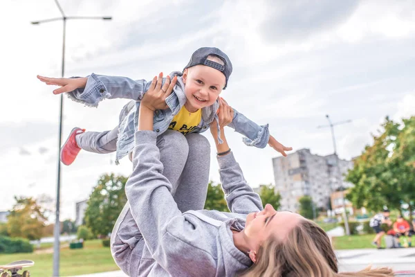 Mutlu, genç bir aile, 3-5 yaşlarında küçük bir çocuk, anne kadın, yazın şehir parkında eğleniyor. Spor sahasında hafta sonu dinlenmesi. Günlük kıyafet. Sevgi ve ebeveynlik duyguları. — Stok fotoğraf