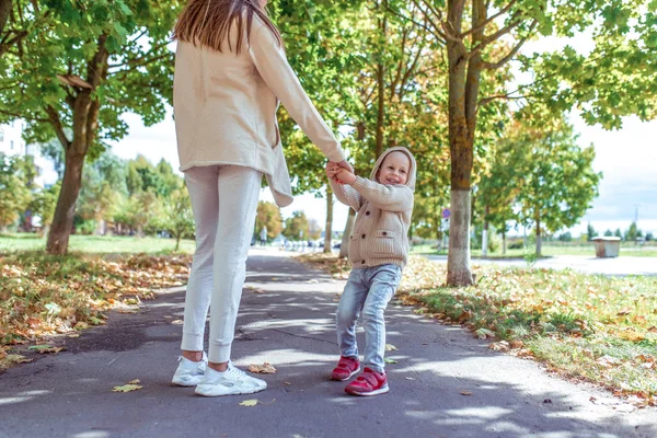 Ibu wanita berjalan dengan anaknya, anak laki-laki, anak laki-laki berusia 4-5 tahun, hari musim gugur di jalan di taman, orang-orang bahagia bermain, bersenang-senang dan tertawa, pakaian sehari-hari bahagia dengan kerudung . — Stok Foto
