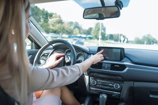 Nő egy autó szalonban, ujj kiválasztja az alkalmazást az érintőképernyőn a tabletta. Nyáron a városban. Válassza ki az útvonaltérkép mozgását. Érintőképernyős monitor. — Stock Fotó