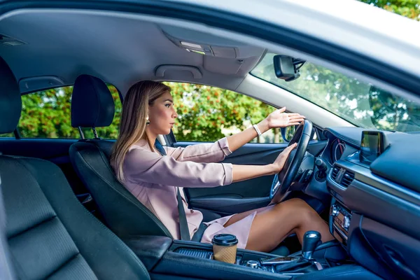Woman in the car, horn signal, accident and accident on the road, hand gesture. Negative reaction, harsh criticism, traffic jam, poor car driving. Summer city. — Stock Photo, Image