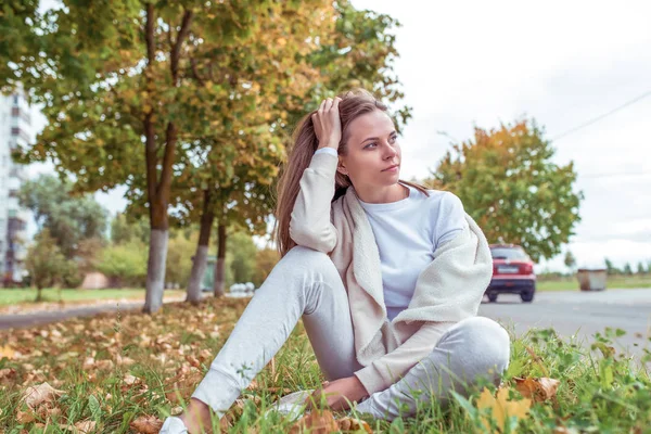 Gadis cantik di musim gugur hari di taman, duduk beristirahat, pakaian hangat santai, jaket putih, sweater krem. Ruang kosong untuk menyalin teks. Emosi kenyamanan dan relaksasi akhir pekan . — Stok Foto