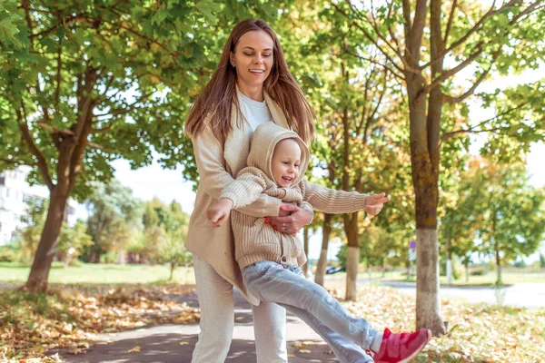 Žena matka, šťastný smích a baví hrát si s malým chlapcem syn 4-5 let, podzimní park ve městě. Teplé neformální oblečení. Pojem rodičovství, láska k dětem. Emoce zábava potěšení zábava. — Stock fotografie
