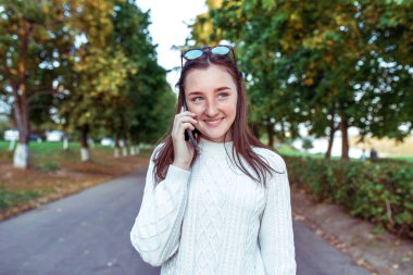 Mutlu kız gülümsemesi, genç kız, akıllı telefon eli, sesli mesaj dinleme, internet uygulaması. Sosyal ağlar. Hafta sonu dinlen. Mutluluk duyguları, eğlence eğlence zevki.
