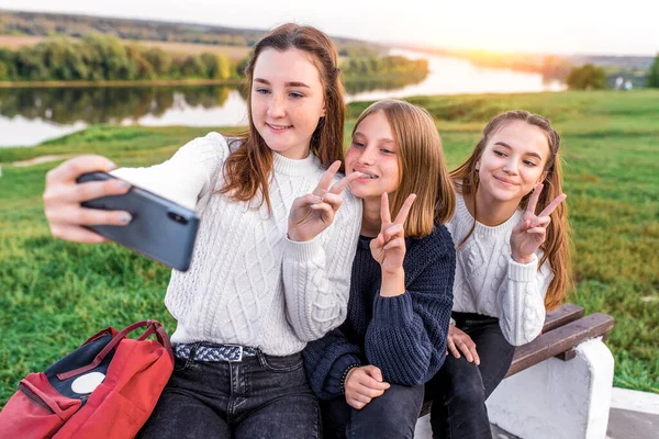 3 dívky dospívající 12 13 14 let, léto, držící smartphone ruce, selfie fotografie. Prázdninový víkend, nejlepší přátelé, emoce radostného úsměvu. Sociální sítě na Internetu, online aplikace. — Stock fotografie