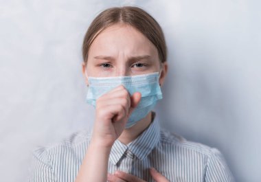 Genç kız, koruyucu maske, ağzının üzerini eliyle kapatıyor, öksürük ve boğaz ağrısı, hastalık kötü sağlık, koronavirüs COVID-19 bulaşıcı hastalık salgını koruması, sağlık sigortası konsepti