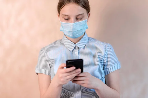 Teenager dívka, ochranná maska, píše zprávu na smartphone, on-line video Internet aplikace, anti-coronavirus COVID-19 pandemie infekční onemocnění ochrana epidemie, zdravotní koncepce — Stock fotografie