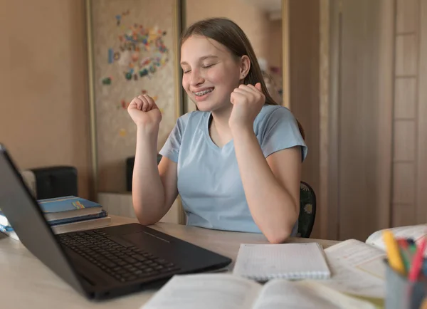 Glückliches Teenagermädchen lächelt, freudiges lacht viel Glück und Gewinn, erfolgreiche Zulassung zum College und College, Online-Videotraining, Laptop mit Internet. Fernstudium unter Quarantäne, zu Hause bleiben. — Stockfoto