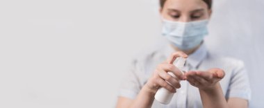 Genç kız maskesi, antiseptik sprey şişesi, el bakterisi, virüs enfeksiyonunu önleme güvenliği, dikkatlice grip hastalığı, evde kal, salgını durdur. Metin pankartı sitesi için boş alan.