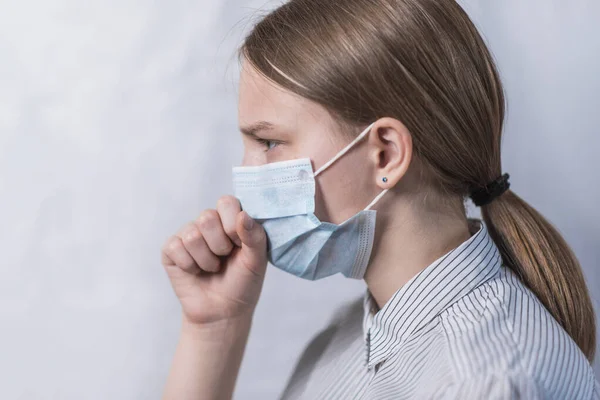 Έφηβο κορίτσι με ιατρική μάσκα, βήχα και πονόλαιμο, ασθένεια και θερμοκρασία, πλευρική άποψη γκρο πλαν, νόσος του ιού προσοχή και γρίπη και ασθένεια, μείνετε στο σπίτι, να σταματήσει η πανδημία του covius coronovirus covid 19. — Φωτογραφία Αρχείου