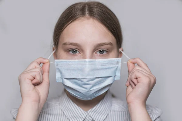 Έφηβος κορίτσι 12-15 ετών, πρόσωπο που καλύπτεται με ιατρική μάσκα, γκρο πλαν πορτρέτο, ιός αποκατάστασης πάνω, αφαιρεί τη μάσκα, προσεκτικά τη νόσο του ιού της γρίπης, μείνετε στο σπίτι, να σταματήσει η πανδημία του covid coronovirus 19 — Φωτογραφία Αρχείου