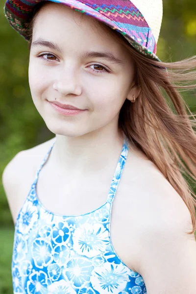Nahaufnahme Porträt eines Kindes, schöne kleine Teenager-Mädchen mit Hut, Sommer im Freien, Emotionen des Glücks lächelt und Entspannung. Lange Haare entwickeln sich im Wind. — Stockfoto