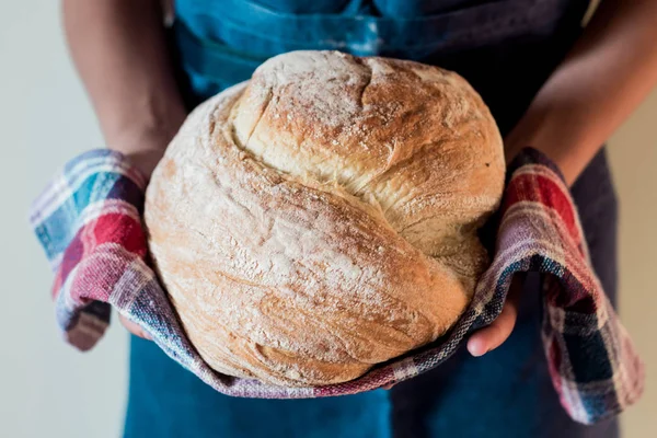 Yuvarlak somun ekmek bir kadın elinde