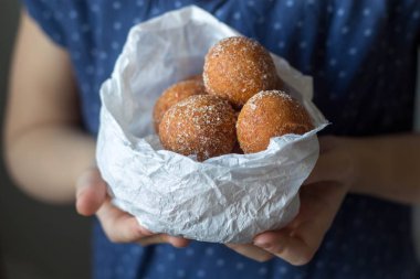 Mini donuts bir kızın elinde bir kağıt torba 