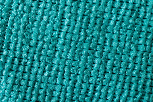 Turquoise texture of a textile fiber cloth. Empty background of turquoise color. Microfiber cloth texture background close up