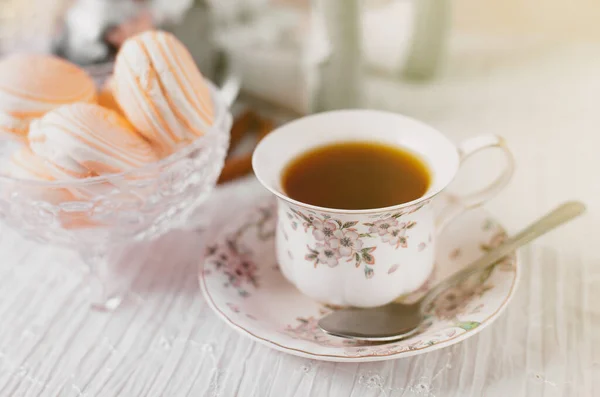 Photo related to the International Tea Day. Cup of tea in a table with macarons. Monochromatic colors. Stylish image. International Tea Day backdrop. Decorative table with food and tea.