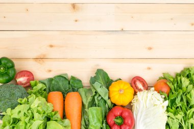 Brokolili sebze çerçevesi, balkabağı, havuç, biber, domates, parlak ahşap masada marul..