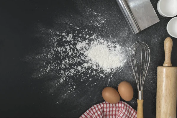 Un ve un dolu yumurtalar siyah masa üzerine serpilmiş fırın konsepti..