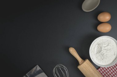 Tahta hamur silindiri, bir bardak un, yumurta ve çırpı. Pastane ev yapımı konsept.