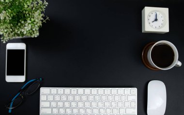 Klavye, fare, saat, bir fincan kahve ve gözlüklü siyah ya da koyu ofis masası. Kopyalama alanı olan üst görünüm. Çalışma masası konsepti.