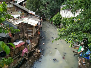 Tanah abang, Jakarta, Endonezya _ 8 Nisan 2020: sel baskınına eğilimli bir nehrin kenarındaki bir evin atmosferi. Fotoğraf köprüden çekildi.