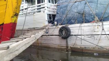 Sunda Kelapa Limanı. Kamyonlardan limandaki kargo gemilerine mal taşıyan işçilerin atmosferi.