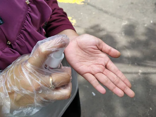 the hand that is spraying the hand sanitizer