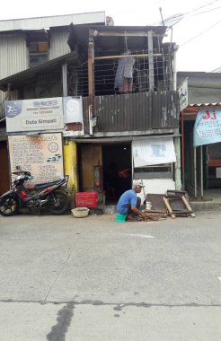 Sudirman, Jakarta, Endonezya - 15 Temmuz 2016: Bir büyükbaba yol kenarında kendi evini onarıyor