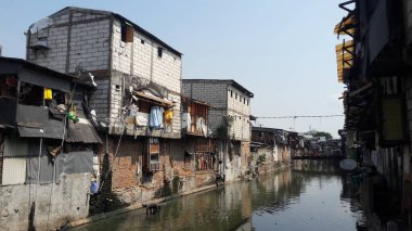 Batı Cakarta, Endonezya - 28 Ekim 2018 Kirli bir nehrin kıyısındaki gecekondu bölgesi