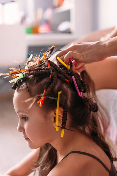 Mom made her daughter a hairstyle, a lot of curls, daughter is happy and plays with curls