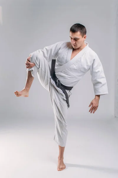 Mladý Silný Chlap Karate Bílém Kimonu Studiu Bílém Pozadí Provádí — Stock fotografie