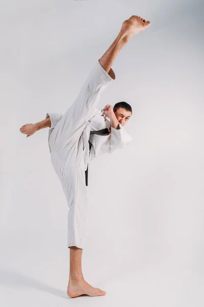 Mladý Silný Chlap Karate Bílém Kimonu Studiu Bílém Pozadí Provádí — Stock fotografie