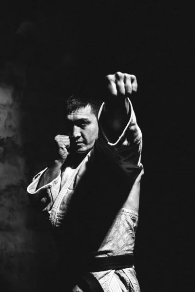 Mladý Silný Chlap Karate Bílém Kimonu Ateliéru Černém Pozadí Provádí — Stock fotografie