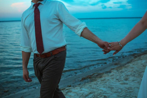 新婚夫妇 傍晚时分 他们手牵手在湖边散步 — 图库照片