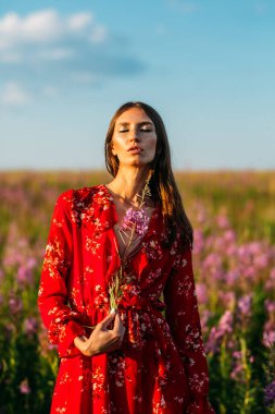Güzel, uzun boylu, genç kız, uzun saçlı, kırmızı çiçekli kırmızı elbiseli..