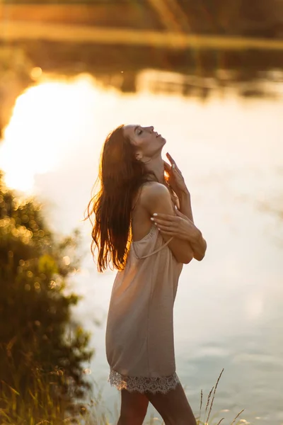 美しい女の子が川の岸に沈む夕日空緑 — ストック写真